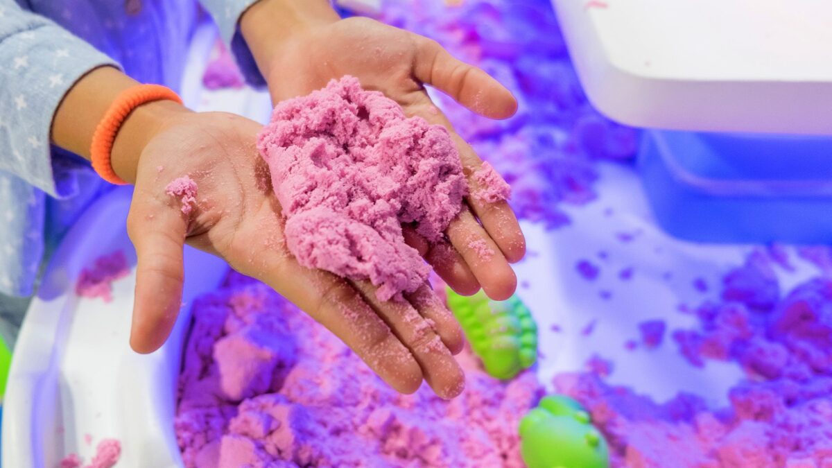 Gekleurd kinetisch zand op handen