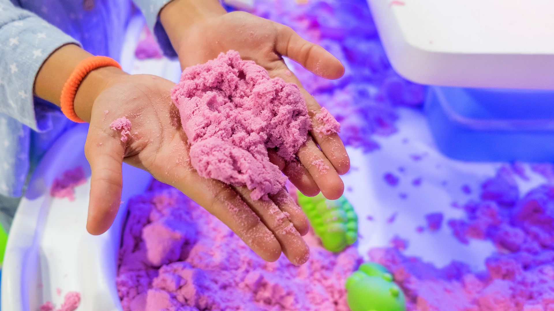 Gekleurd kinetisch zand op handen