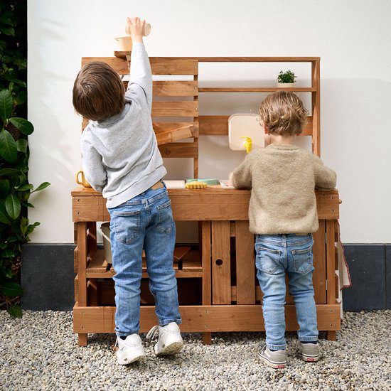 Twee kindjes spelen in de buitenkeuken van Petit Amelie