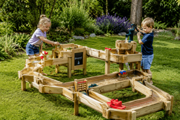 Kinderen spelen met waterbaan in de tuin