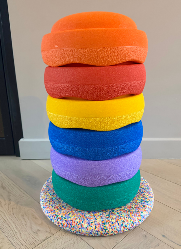 Stapelstein Original en Balance Board voor een beige muur.