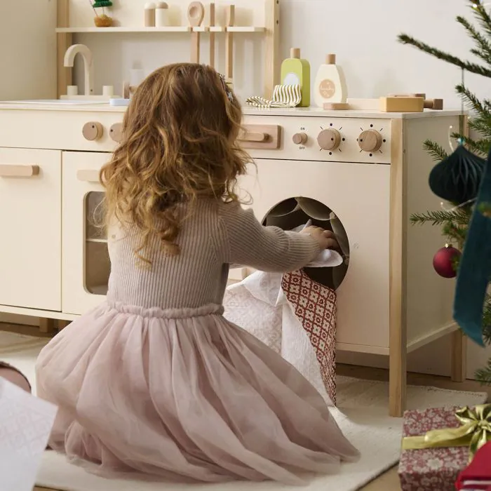 Meisje speelt met de speelgoed wasmachine van Petit Amelie